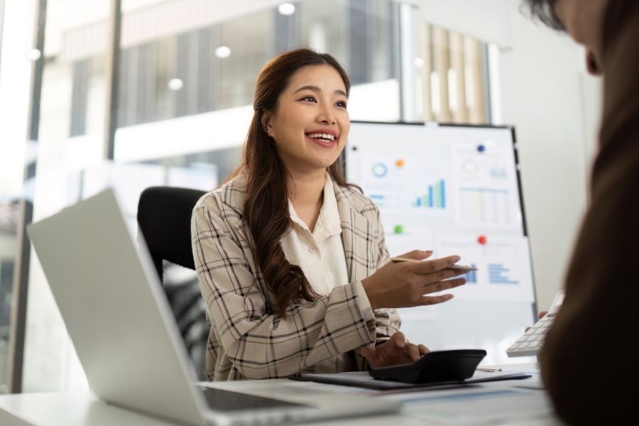 Professional Accounting Consultation. Young woman explaining financial data to a client in an office.